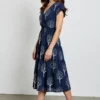 Navy blue wrap midi dress with tree print, featuring tiered design, V-neck, short sleeves, and an elegant natural style, suitable for daily wear or mature casual looks.
