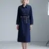 Dark blue belted denim shirt dress with collar, front buttons, pockets, featuring a minimalist and elegant design, suitable for daily or light formal wear.