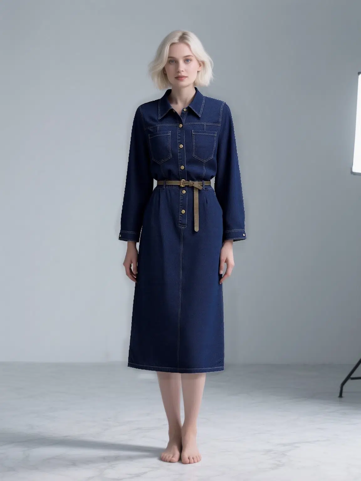 Dark blue belted denim shirt dress with collar, front buttons, pockets, featuring a minimalist and elegant design, suitable for daily or light formal wear.