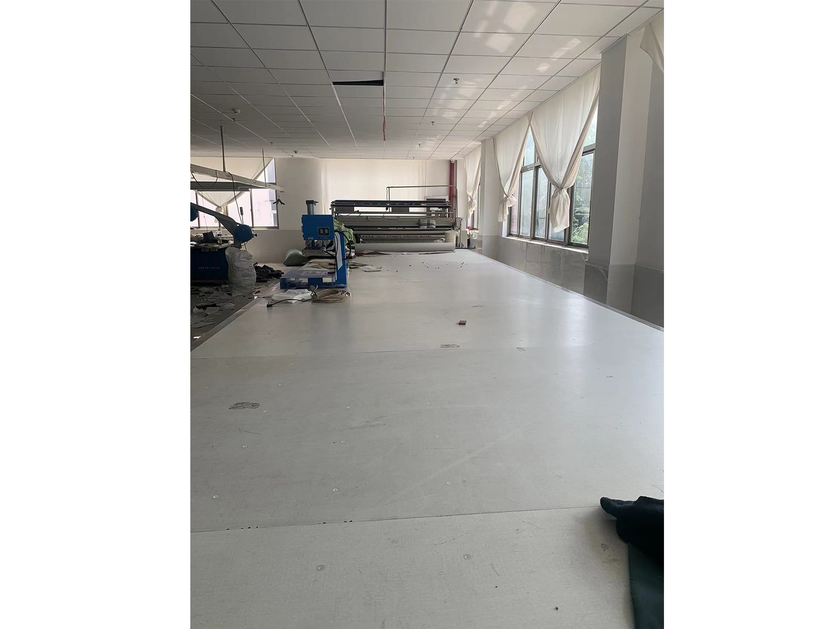 Clothing production workshop with machinery, spacious and industrial for production site display.