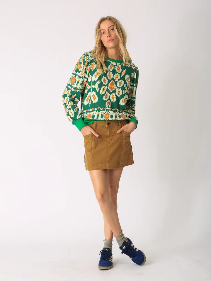 Brown dyed mini skirt with floral patterned green top (front view)
