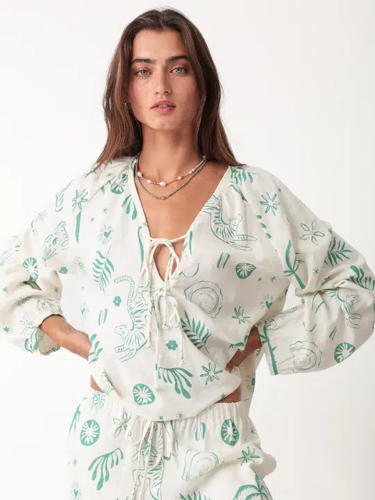 100% linen printed loungewear set with green plant and animal prints on white background, including a tie - front top and matching pants, casual and comfortable design