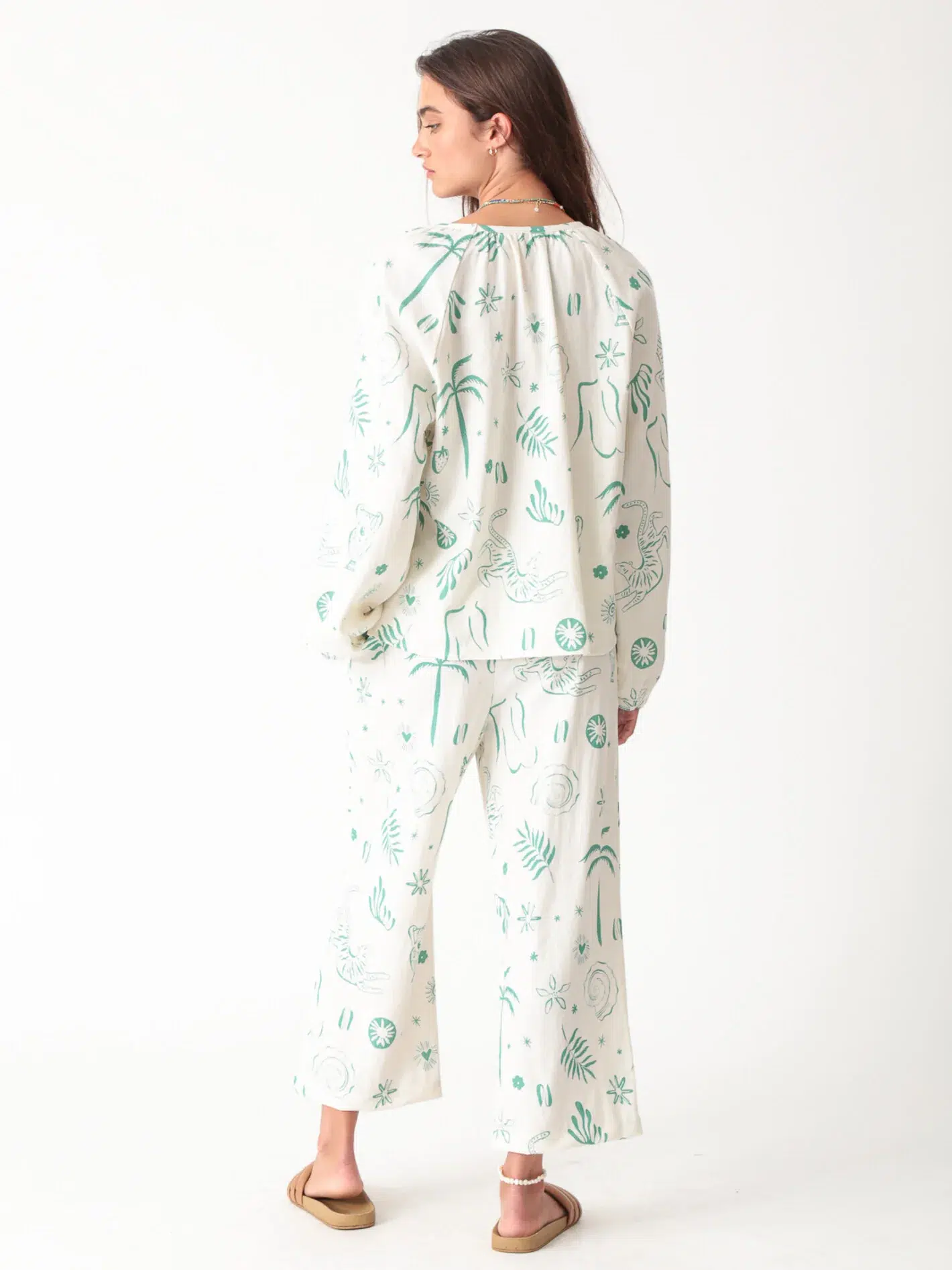 100% linen printed loungewear set with green plant and palm tree prints on white background, including a top and wide - leg pants, casual and comfortable design