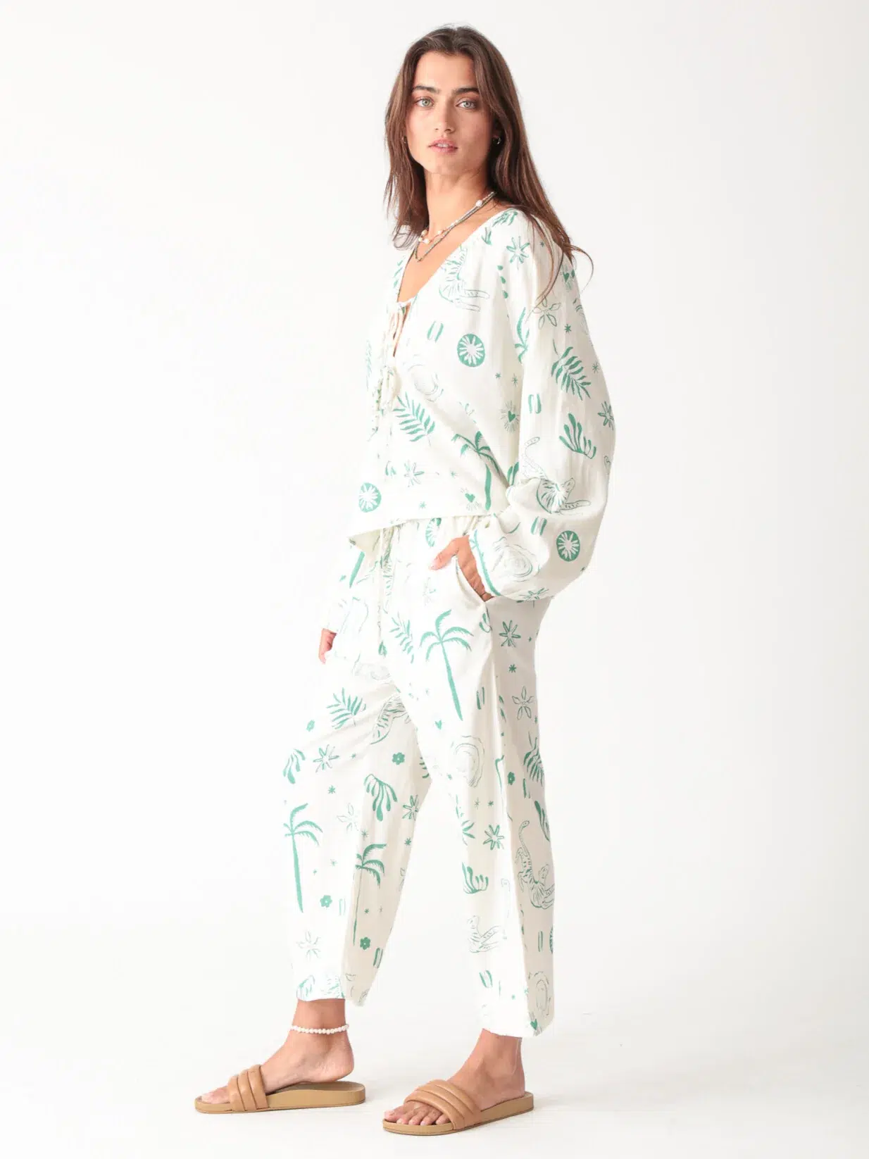 100% linen printed loungewear set with green plant and palm tree prints on white background, including a top and wide - leg pants, casual and comfortable design