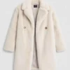 Light beige faux fur long coat with notched lapels and double - breasted buttons, displayed against a light background.