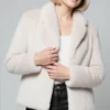 light beige faux fur short Smoothie Jacket-half front view Woman wearing a light beige faux fur short jacket, paired with a white top and black leather pants.