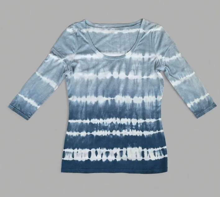 Blue and white tie - dye three - quarter sleeve top displayed against a gray background.