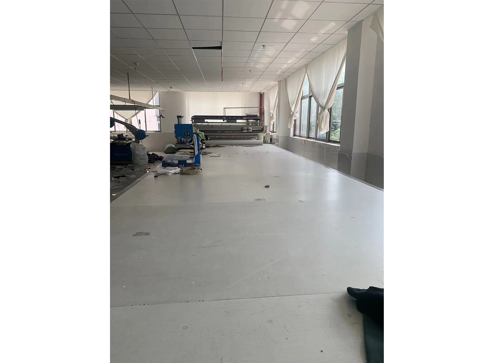 Clothing production workshop with machinery, spacious and industrial for production site display.