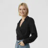 black-wrap-front-blouse-with-blue-denim-bottoms.jpg Black wrap - front collared long - sleeve blouse paired with blue denim bottoms, featuring a minimalist and sleek design, suitable for daily or light workplace wear.