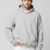 Model wearing light gray hoodie with button accents