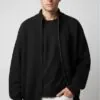 Model wearing black zip - up knitted cardigan
