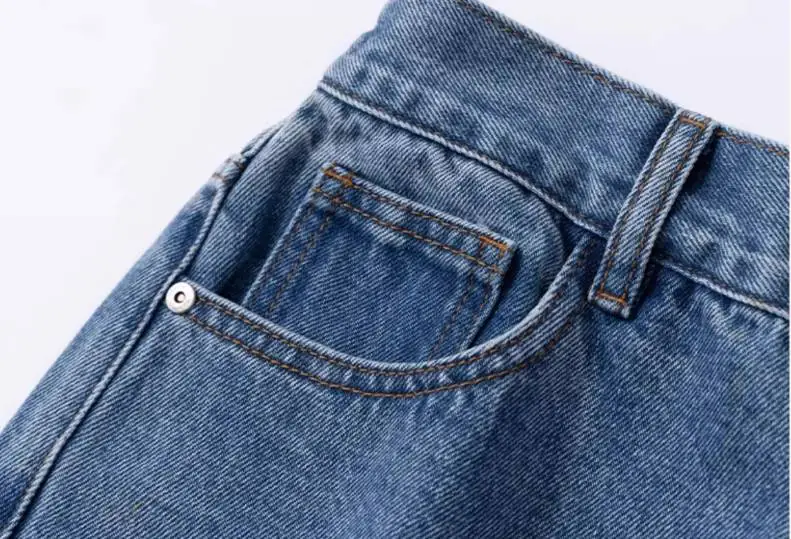 Detail view of light blue wide-leg jeans’ back pocket (stitching, button, and fabric)