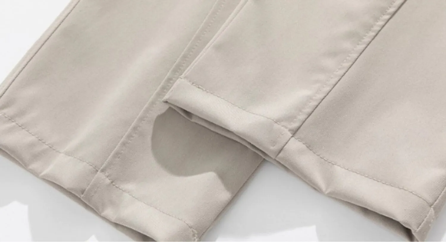Detail view of light beige drawstring wide-leg trousers (hem stitching and fabric texture)