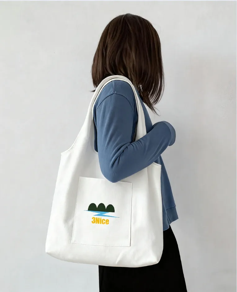 Model carrying white canvas tote bag with "3Nice" text and landscape graphic