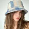blue-white-plaid-fuzzy-bucket-hat-model.jpg Model wearing blue and white plaid fuzzy bucket hat