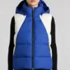 Outfit with blue - white colorblock hooded puffer vest, black innerwear, and dark jeans, featuring a casual, warm, and fashionable design suitable for autumn and winter.