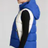 Outfit with blue - white colorblock hooded puffer vest, black innerwear, and dark jeans, featuring a casual, warm, and fashionable design suitable for autumn and winter.