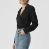 black-wrap-front-blouse-with-blue-denim-bottoms.jpeg Black wrap - front collared long - sleeve blouse paired with blue denim bottoms, featuring a minimalist and sleek design, suitable for daily or light workplace wear.