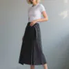 White short - sleeve fitted top paired with dark gray asymmetric denim midi skirt with belt, featuring a minimalist and stylish design, suitable for daily or light workplace wear.
