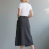 White short - sleeve fitted top paired with dark gray asymmetric denim midi skirt with belt, featuring a minimalist and stylish design, suitable for daily wear or light workplace outfits.