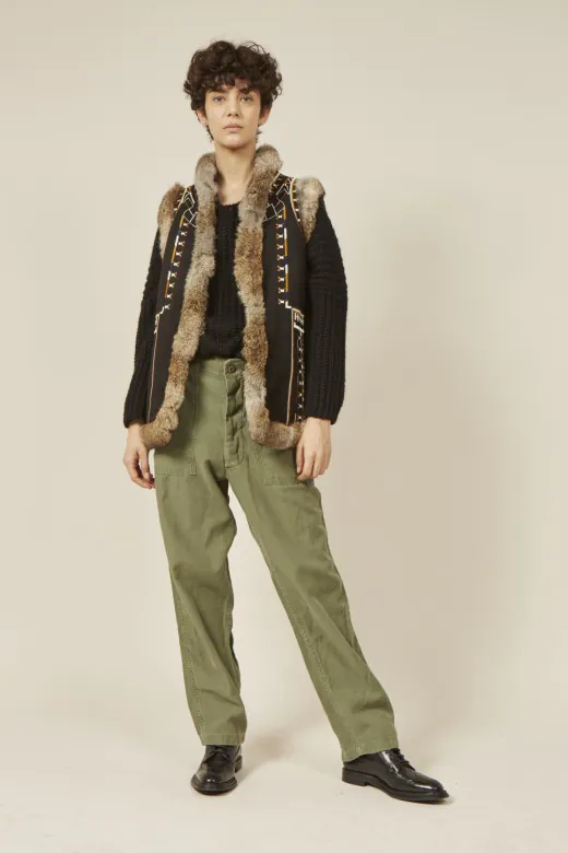 embroidered-fur-trimmed-vest-full-view-model-display.jpg Model wearing embroidered fur - trimmed vest with olive green pants and black shoes